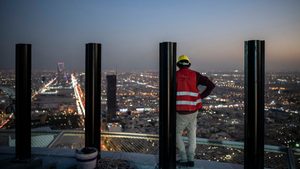 A worker looks out at Riyadh from a tower under construction in the city