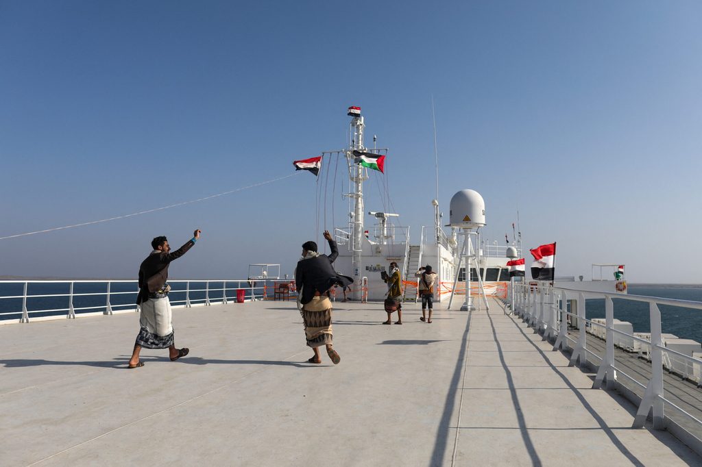 People dance on the deck of the Galaxy Leader, seized by Yemen's Houthis last month, off the coast of al-Salif
