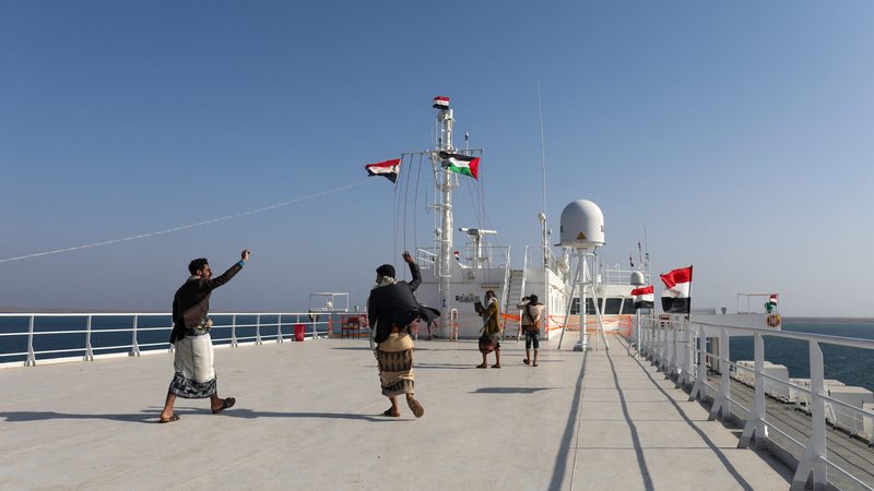 People dance on the deck of the Galaxy Leader, seized by Yemen's Houthis last month, off the coast of al-Salif