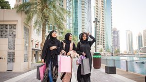 Arabic women with abaya bonding and having fun outdoors - Happy middleastern female friends with traditional muslim dresses meeting and talking while shopping sustainable clothing