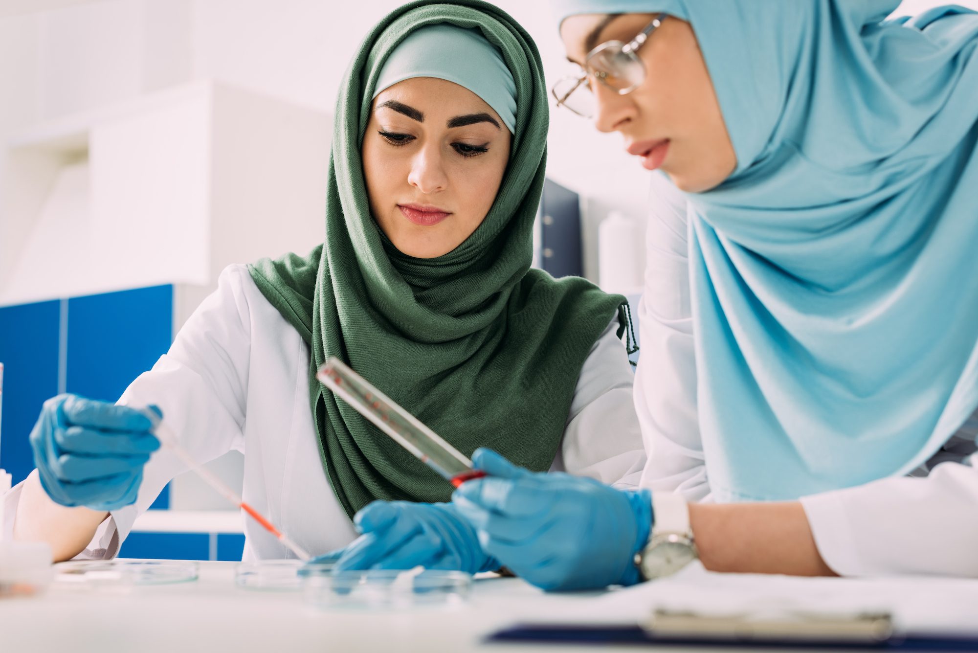 focused female muslim scientists holding pipette and glass test tube during experiment in chemical lab Women in Oman are highly educated, particularly in Stem subjects, compared to peers in the Global North but education does not always equal employment