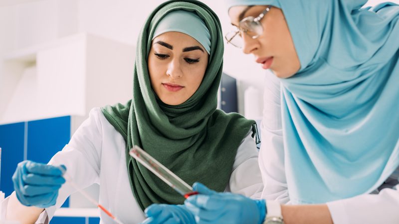 focused female muslim scientists holding pipette and glass test tube during experiment in chemical lab Women in Oman are highly educated, particularly in Stem subjects, compared to peers in the Global North but education does not always equal employment