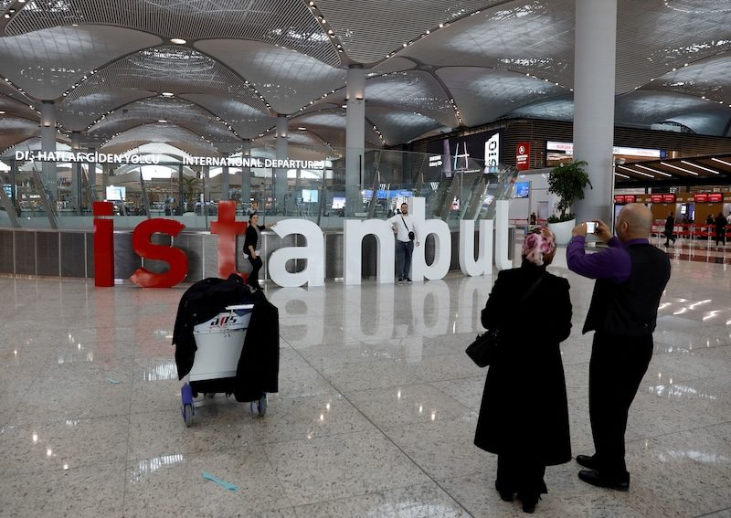 Passengers take photos at Istanbul Airport. Inflation reached 67.07 percent in February