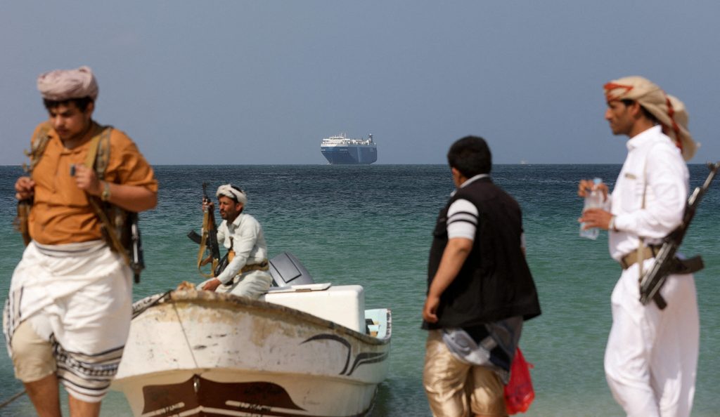 Armed men on the shore at al-Salif, Yemen, following the seizure of the commercial vessel Galaxy Leader owned by Japanese company NYK