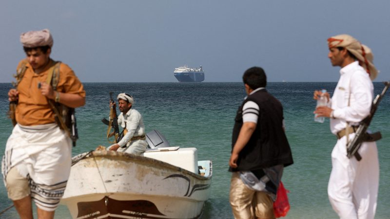 Armed men on the shore at al-Salif, Yemen, following the seizure of the commercial vessel Galaxy Leader owned by Japanese company NYK