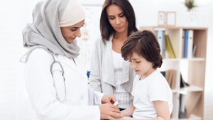 The Arab doctor examines the sick boy. He and his mother came to the hospital. Arabian hospital concept. Pediatrician office and sick child.