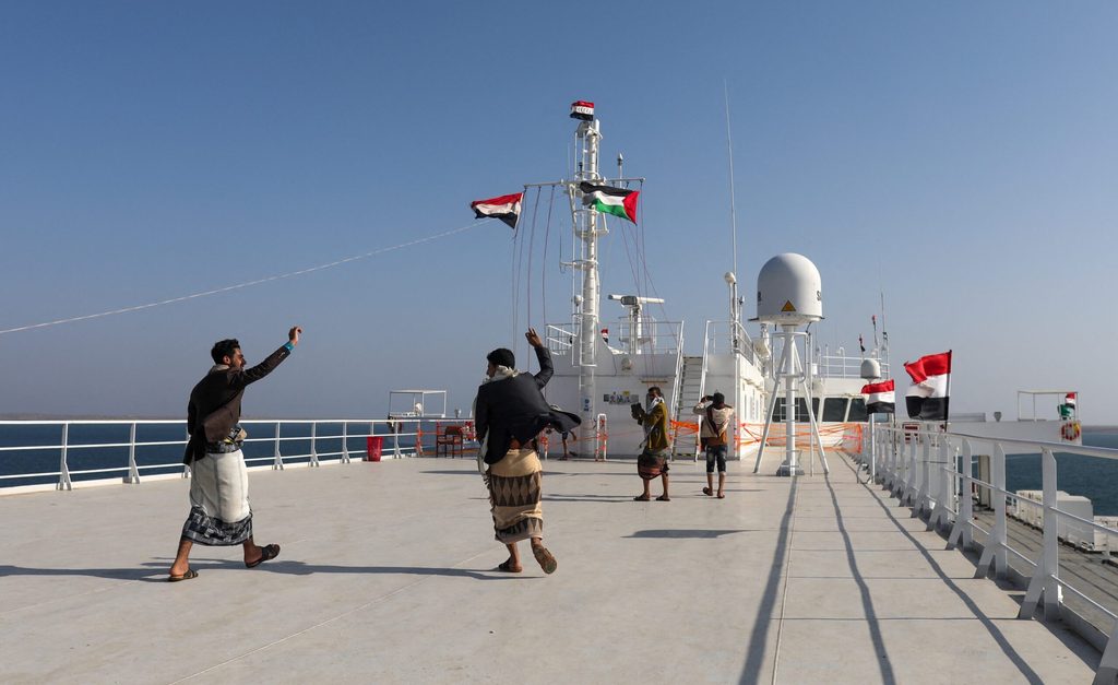People celebrate on the deck of the commercial vessel Galaxy Leader owned by Japanese company NYK after it was seized by Yemen's Houthis