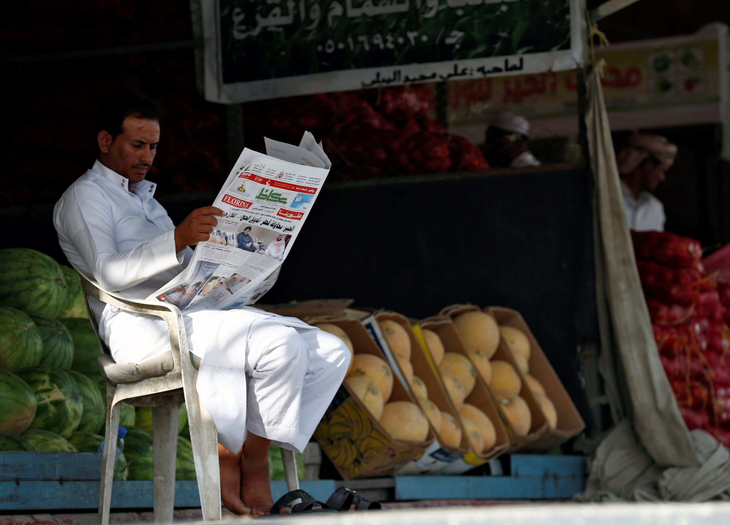 A market vendor reads a newspaper in Riyadh. Saudi media is 'way behind' where it ought to be, said one expert