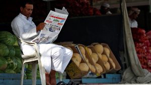 A market vendor reads a newspaper in Riyadh. Saudi media is 'way behind' where it ought to be, said one expert
