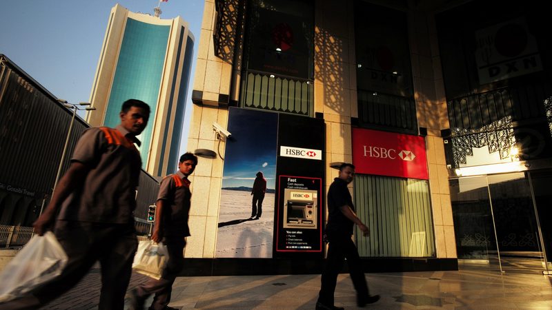 Men walk past an HSBC branch in Manama. HSBC Bank Middle East made pre-tax profit of $1.2bn in 2023