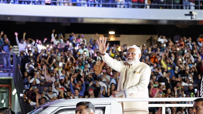 India's PM Narendra Modi waves at supporters gathered at Zayed Sports Stadium in Abu Dhabi on Tuesday