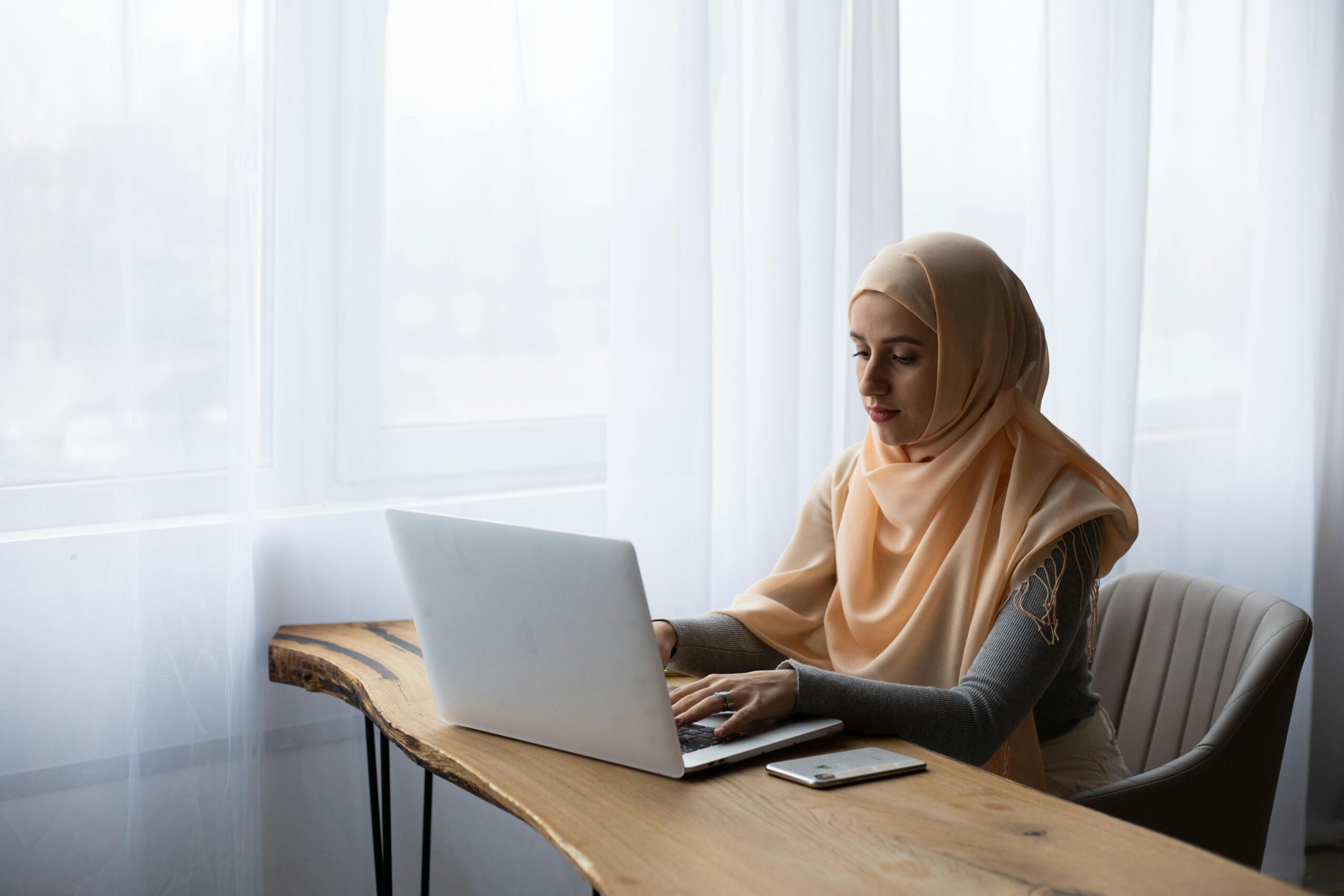 Many authors dream of writing full time free from distractions but the reality is often very different woman writing on laptop minimalist