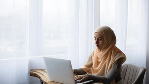 Many authors dream of writing full time free from distractions but the reality is often very different woman writing on laptop minimalist