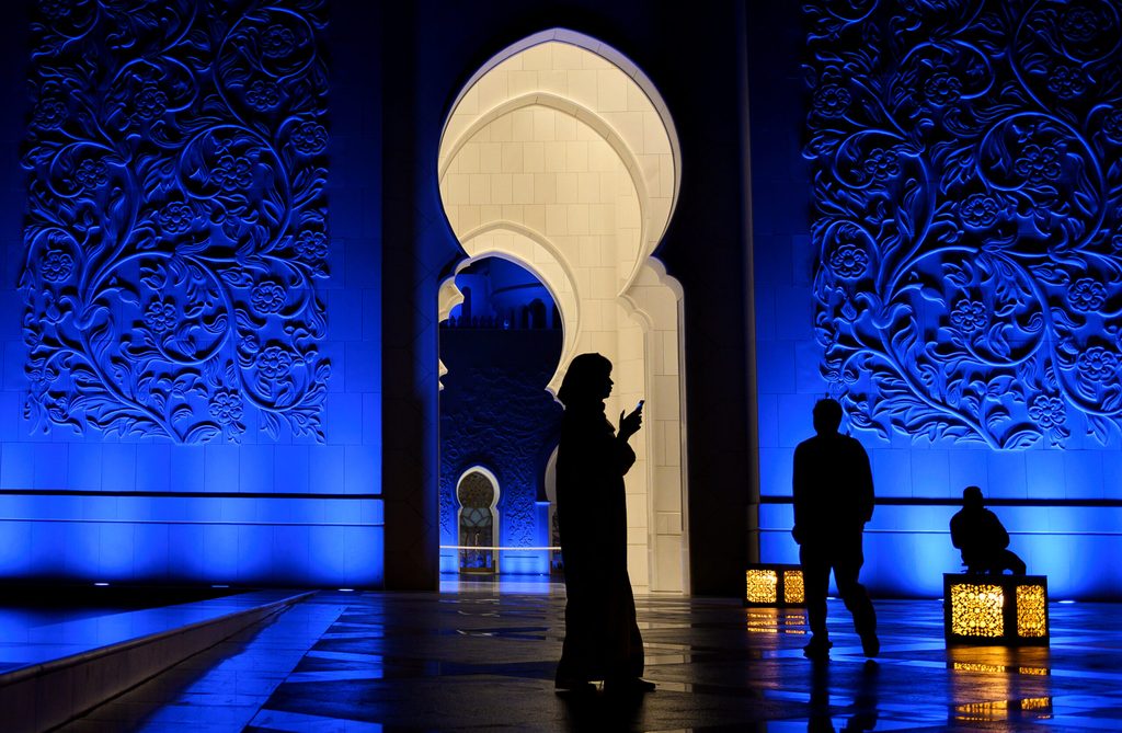 Middle East social media A woman looks at her phone in Sheikh Zayed Grand Mosque