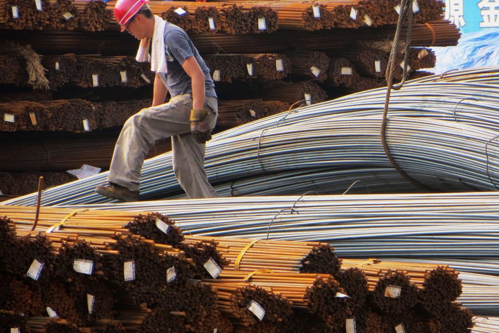 A worker examines rolls of steel rods. Carbon capture can help to reduce emissions from hard-to-abate sectors such as steel production