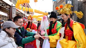 People accept gifts from a man dressed as the Chinese God of Wealth during Spring festival in Zaozhuang, Shandong Province. The region is vital to China's economy
