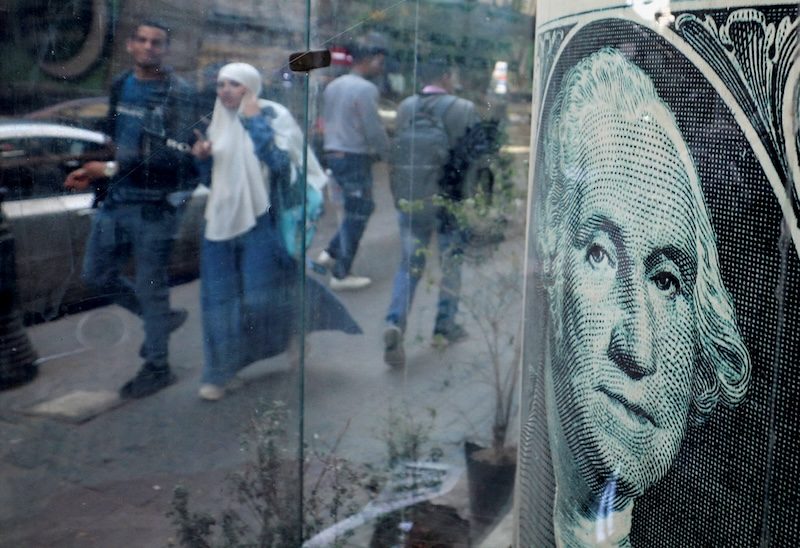People walk past a currency exchange point in Cairo. Egypt has secured billions of dollars of international funding in recent weeks
