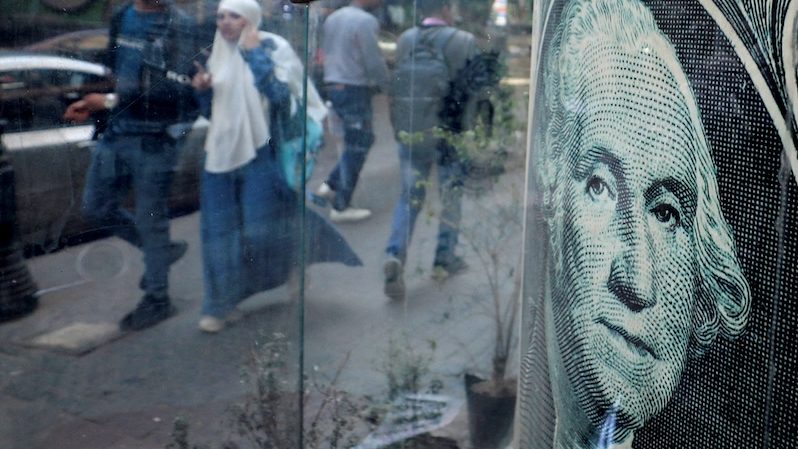People walk past a currency exchange point in Cairo. Egypt has secured billions of dollars of international funding in recent weeks