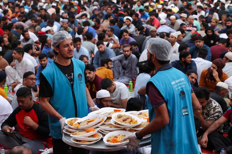 Volunteers distribute meals at a charity Iftar camp in Dubai