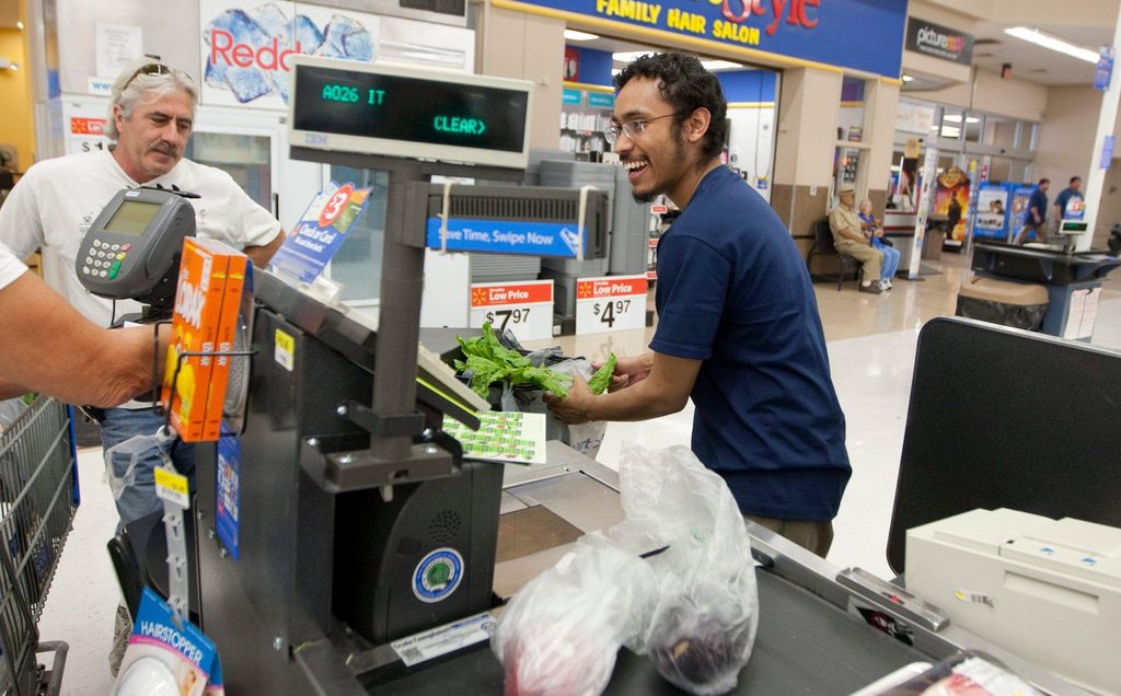 A cashier rings up products at a Walmart store in San Marcos, Texas. Gulf wealth funds invest in US household names such as Walmart and Starbucks