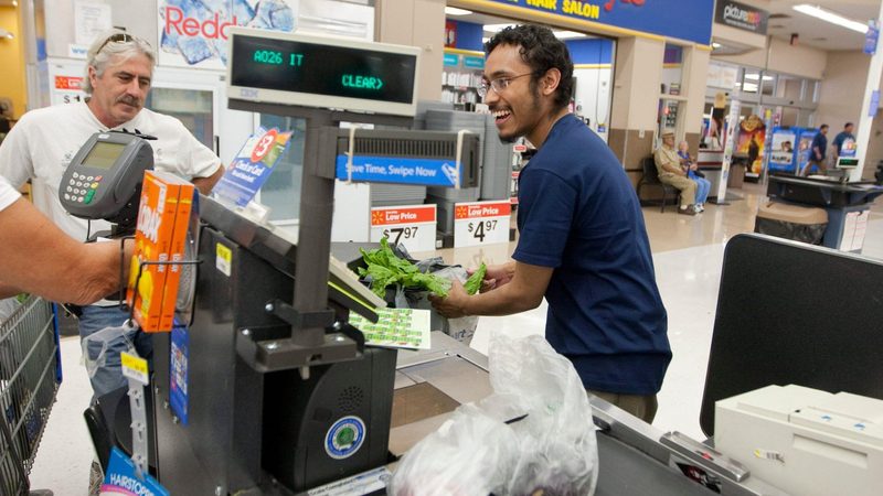 A cashier rings up products at a Walmart store in San Marcos, Texas. Gulf wealth funds invest in US household names such as Walmart and Starbucks