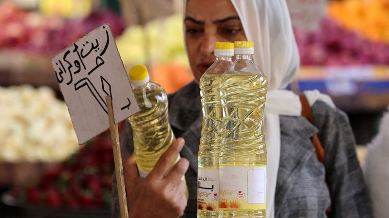 A woman buys cooking oil at a market in downtown Cairo, Egypt