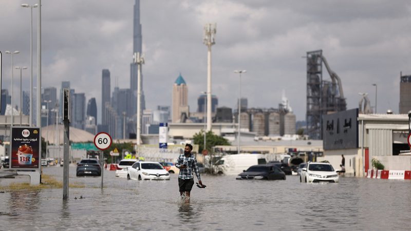 A man wades through a flooded street in Dubai. Some areas of the UAE received more than a year's worth of rain in one day