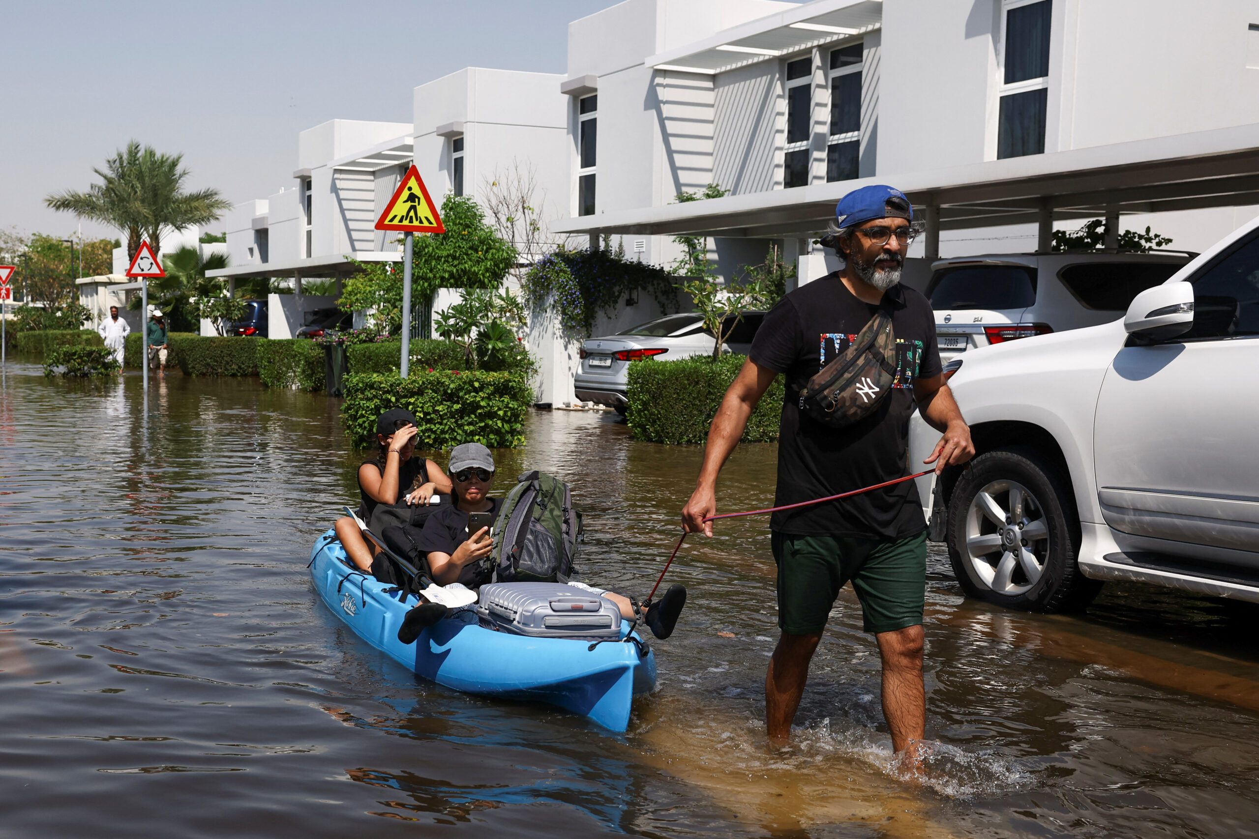 Dubai residents receive help from volunteers as they evacuate their flooded homes