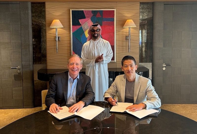 Microsoft president Brad Smith and G42 CEO Peng Xiao (right) sign the $1.5bn investment deal in the presence of G42 chairman Sheikh Tahnoon bin Zayed Al Nahyan