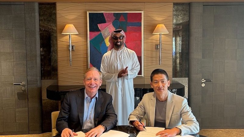 Microsoft president Brad Smith and G42 CEO Peng Xiao (right) sign the $1.5bn investment deal in the presence of G42 chairman Sheikh Tahnoon bin Zayed Al Nahyan