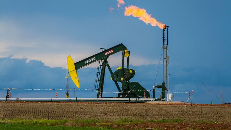 DG8B0G Natural gas flaring and a pumper in the Bakken shale oil fields near Williston, North Dakota, USA.