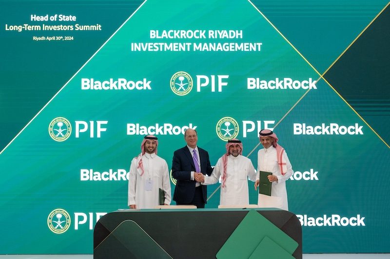 BlackRock chairman and CEO Larry Fink and PIF governor Yasir Al-Rumayyan shake hands at the MOU signing ceremony