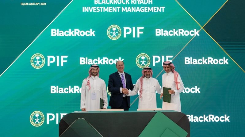 BlackRock chairman and CEO Larry Fink and PIF governor Yasir Al-Rumayyan shake hands at the MOU signing ceremony