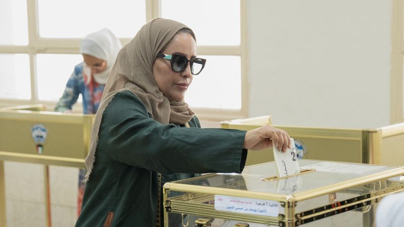 A Kuwaiti citizen drops her ballot into a transparent box after voting to elect new candidates for members of Parliament, in Kuwait City, Kuwait, April 4, 2024. REUTERS/Stephanie McGehee