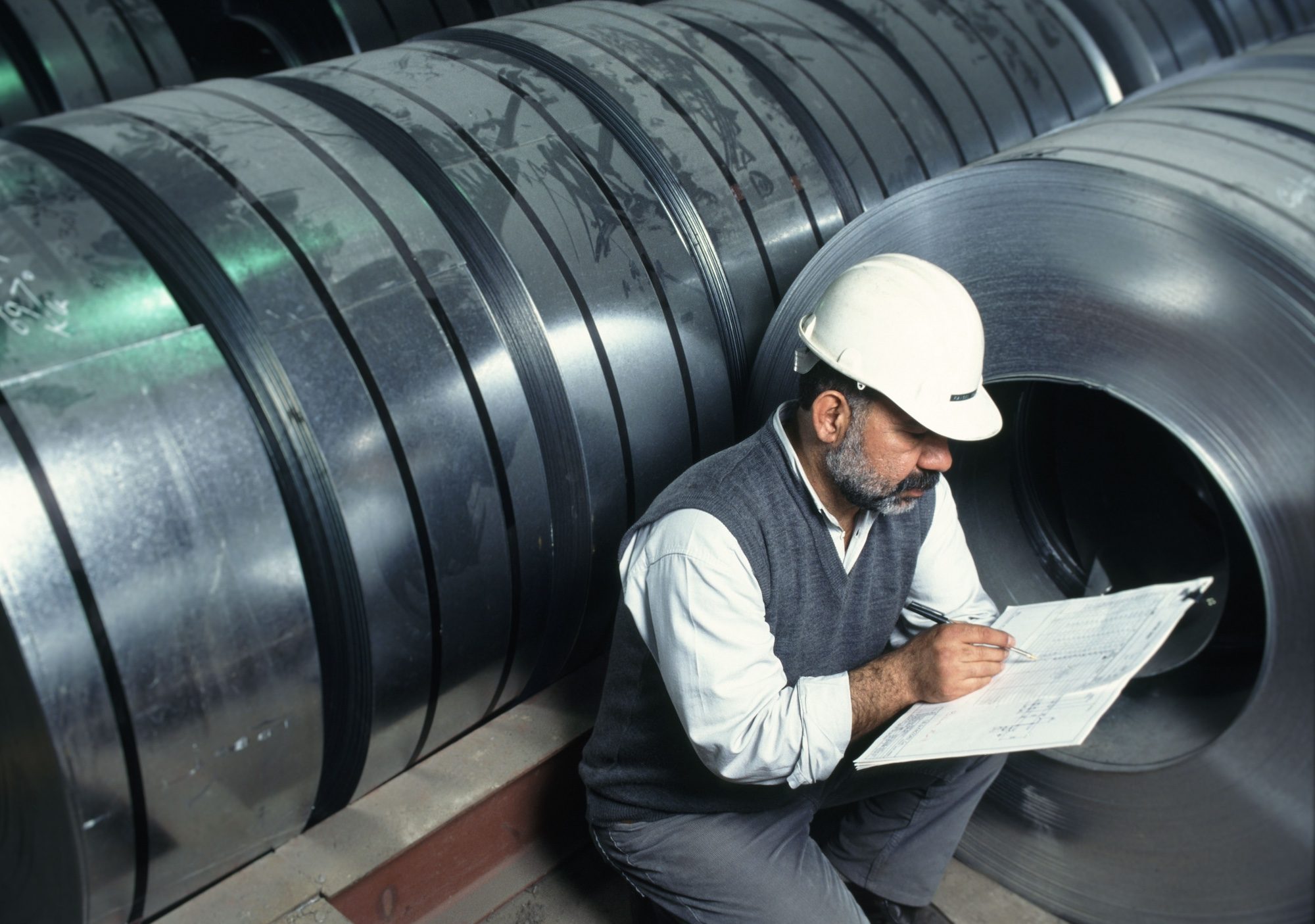 Clothing, Hardhat, Helmet A worker makes notes at a Saudi Arabian steel factory; the industrial production index fell from 114 points in March 2023 to 104 in March 2024