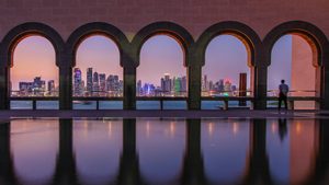 Man looks out at Doha's skyline. Qatar's debt as a percentage of GDP is expected to be just over 37% in 2024