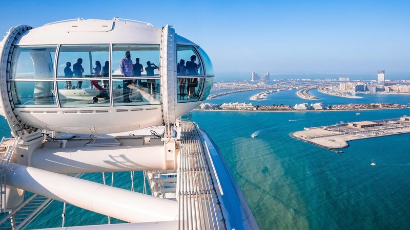 People on the Ain Dubai ferris wheel on Bluewaters Island admire the view of Palm Jumeirah. Both locations were popular with Russian property buyers