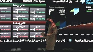 A Tadawul trader looks at prices on the Saudi stock exchange. Aramco's profits have fallen as Riyadh reduces oil output