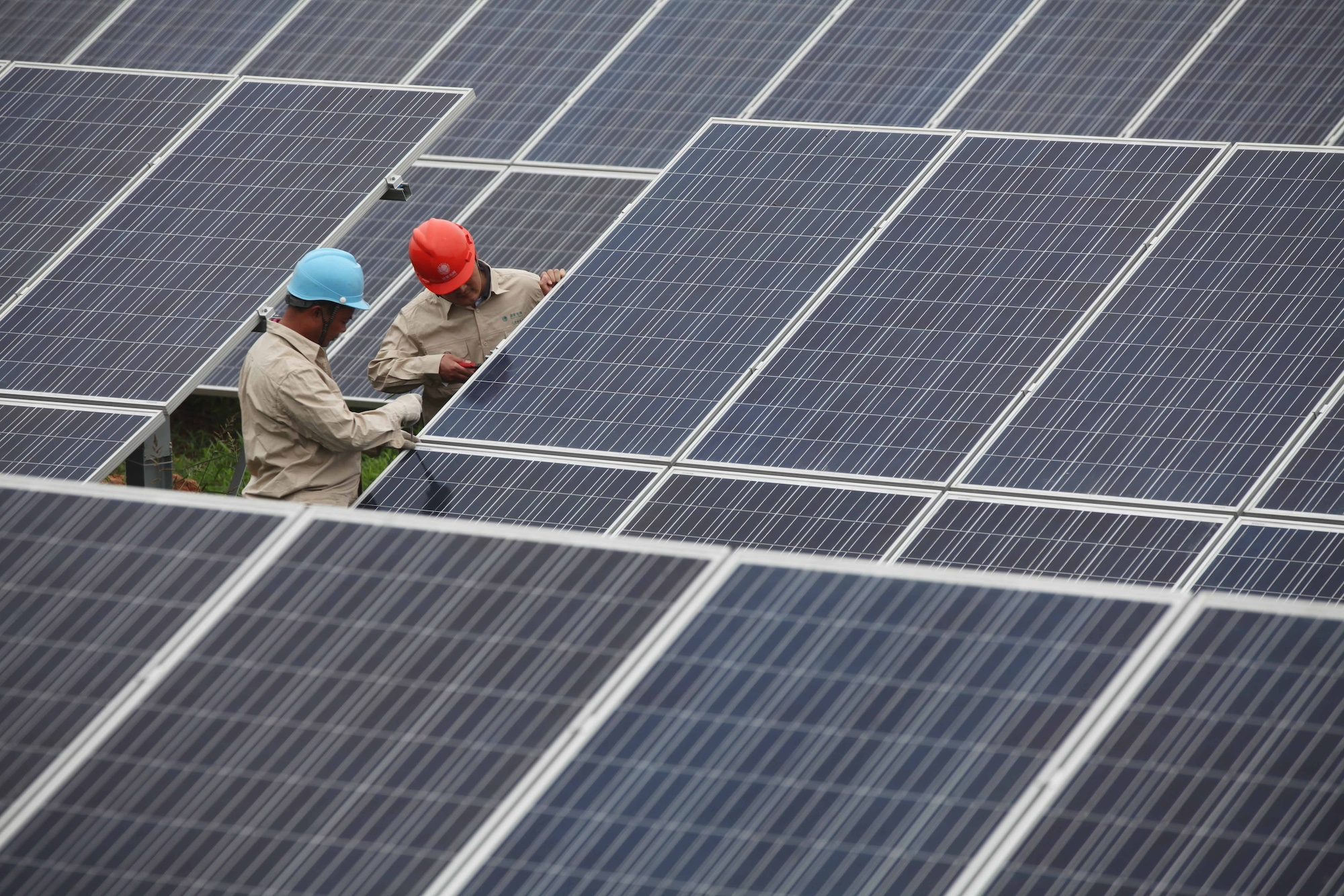 Workers install solar panels. Aluminium is a key component of photovoltaic cells