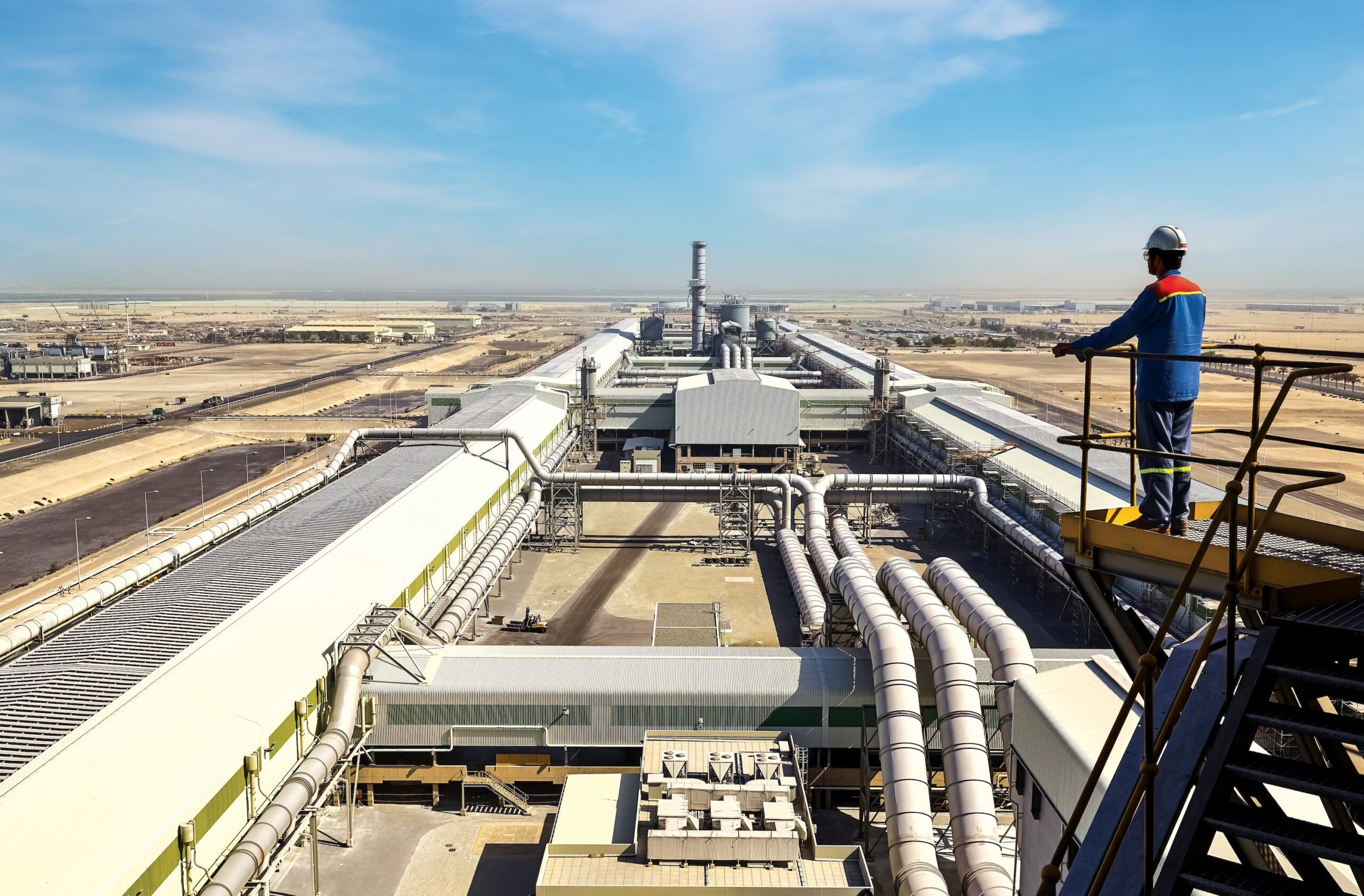 An EGA employee looks out over its Al Taweelah facility in Abu Dhabi. The electricity used in aluminium smelting makes up 60% of its carbon footprint
