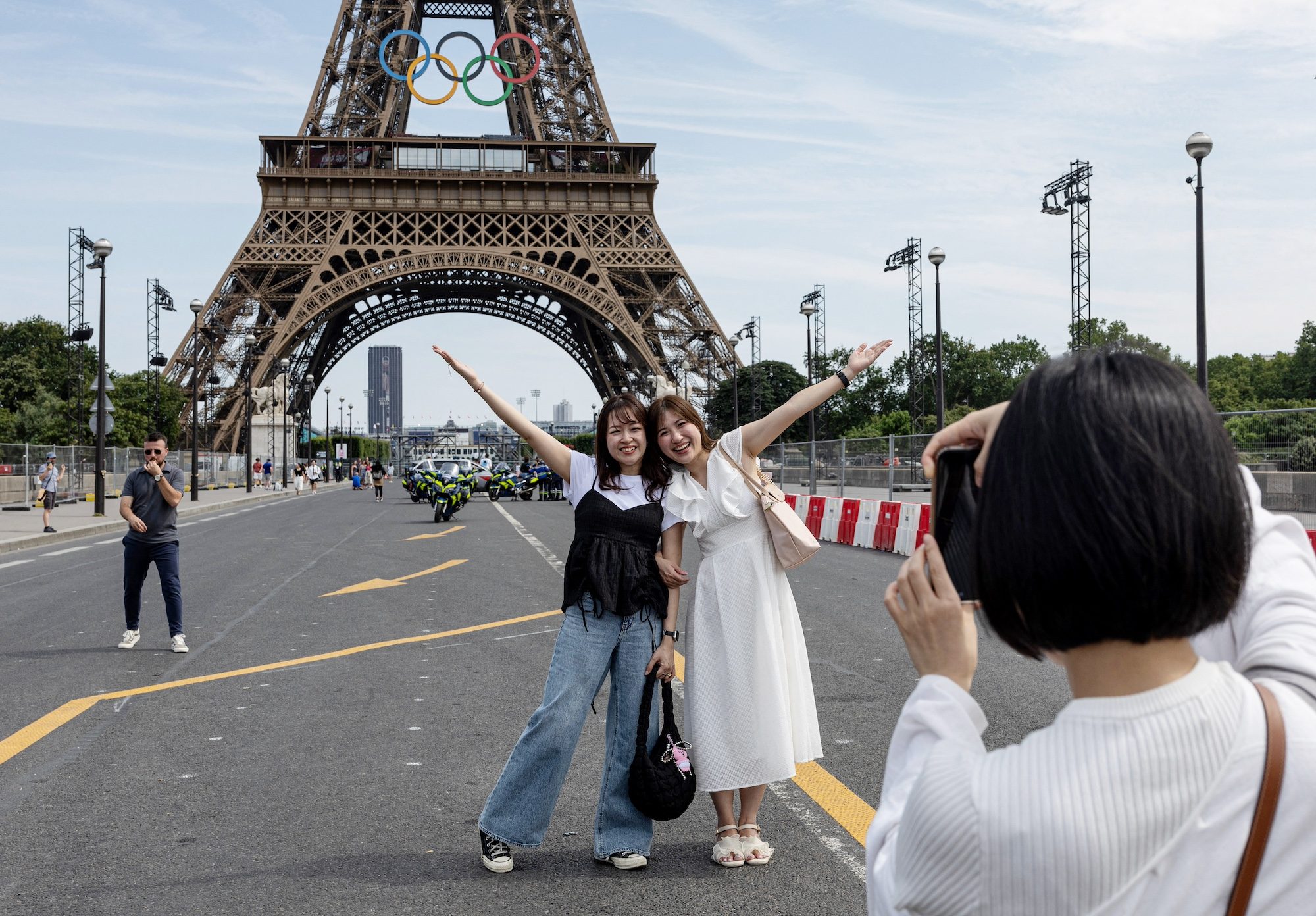 Paris 2024 Olympics - Paris 2024 Olympics Preview - Paris, France - July 18, 2024 People pose for a picture in front of the Eiffel tower ahead of Paris 2024 REUTERS/Marko Djurica