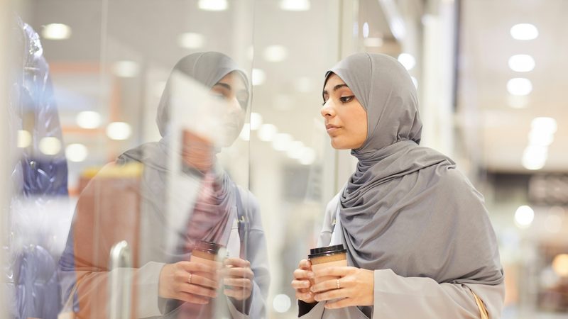 Weaker consumer spending has led retailers to cutting prices in attempt to win customers Woman shopping coffee window