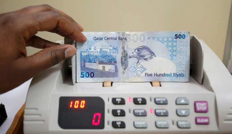 A cashier counts Qatari riyal notes at a money changer in Doha. Estithmar's three-year sukuk offers 8.75 percent coupons