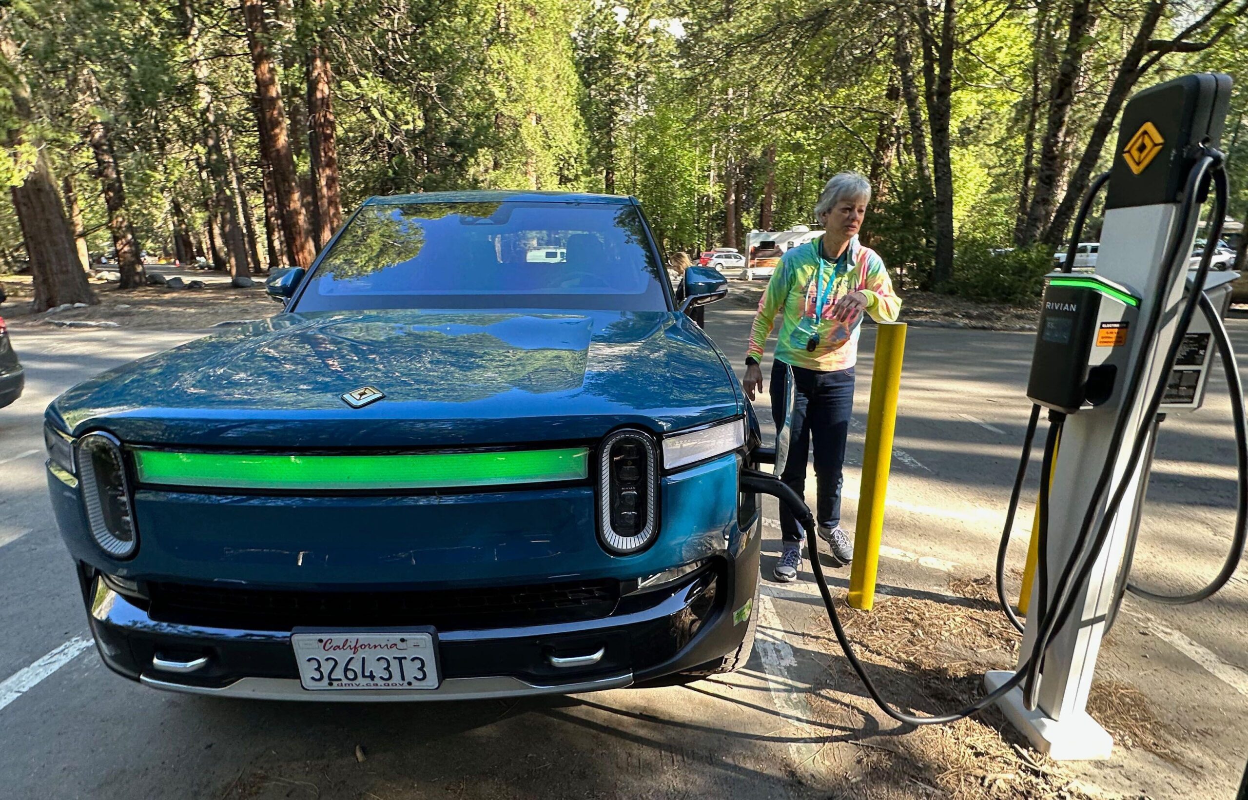 A driver charges her Rivian EV in Yosemite National Park, California. Tesla sales have dropped for the third quarter running