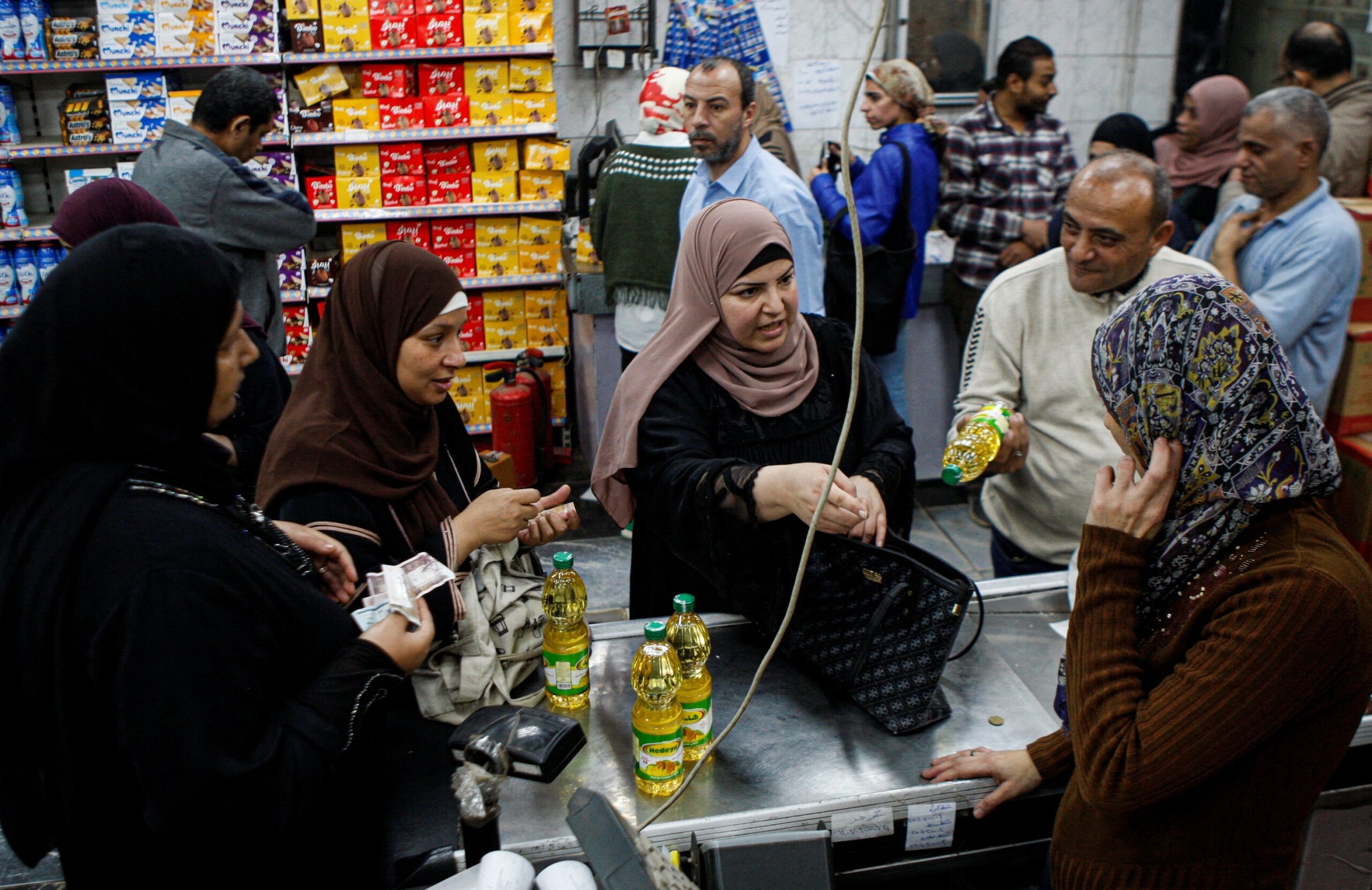 Egyptians buy subsidised food commodities in Cairo. Consumer goods prices fell slightly in July