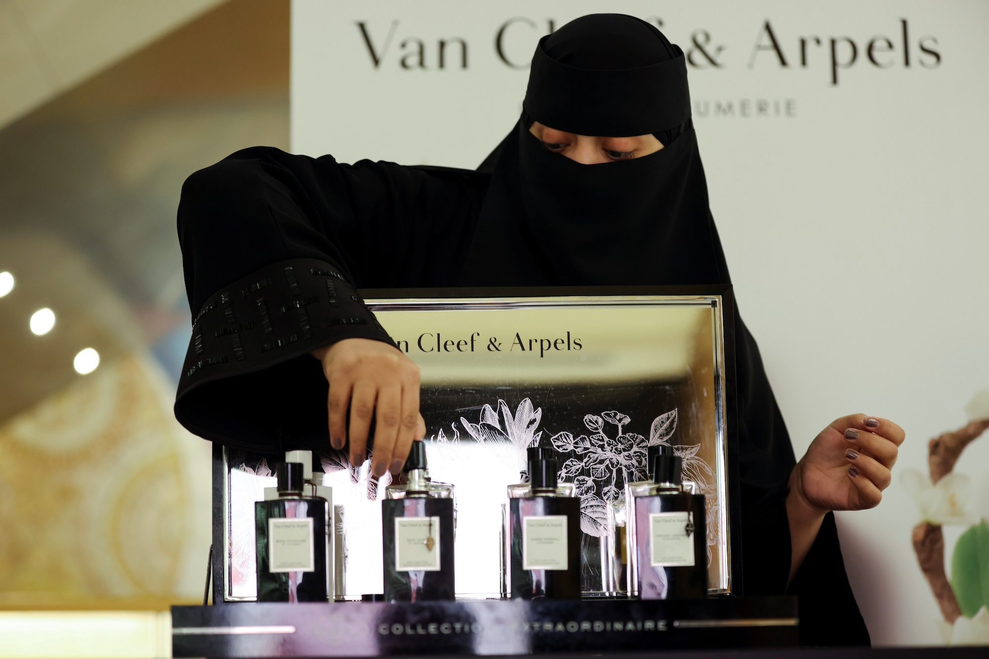 A woman arranges luxury fragrance in a Riyadh mall; Saudi Arabia hopes to increase tourist spending with a tax refund scheme