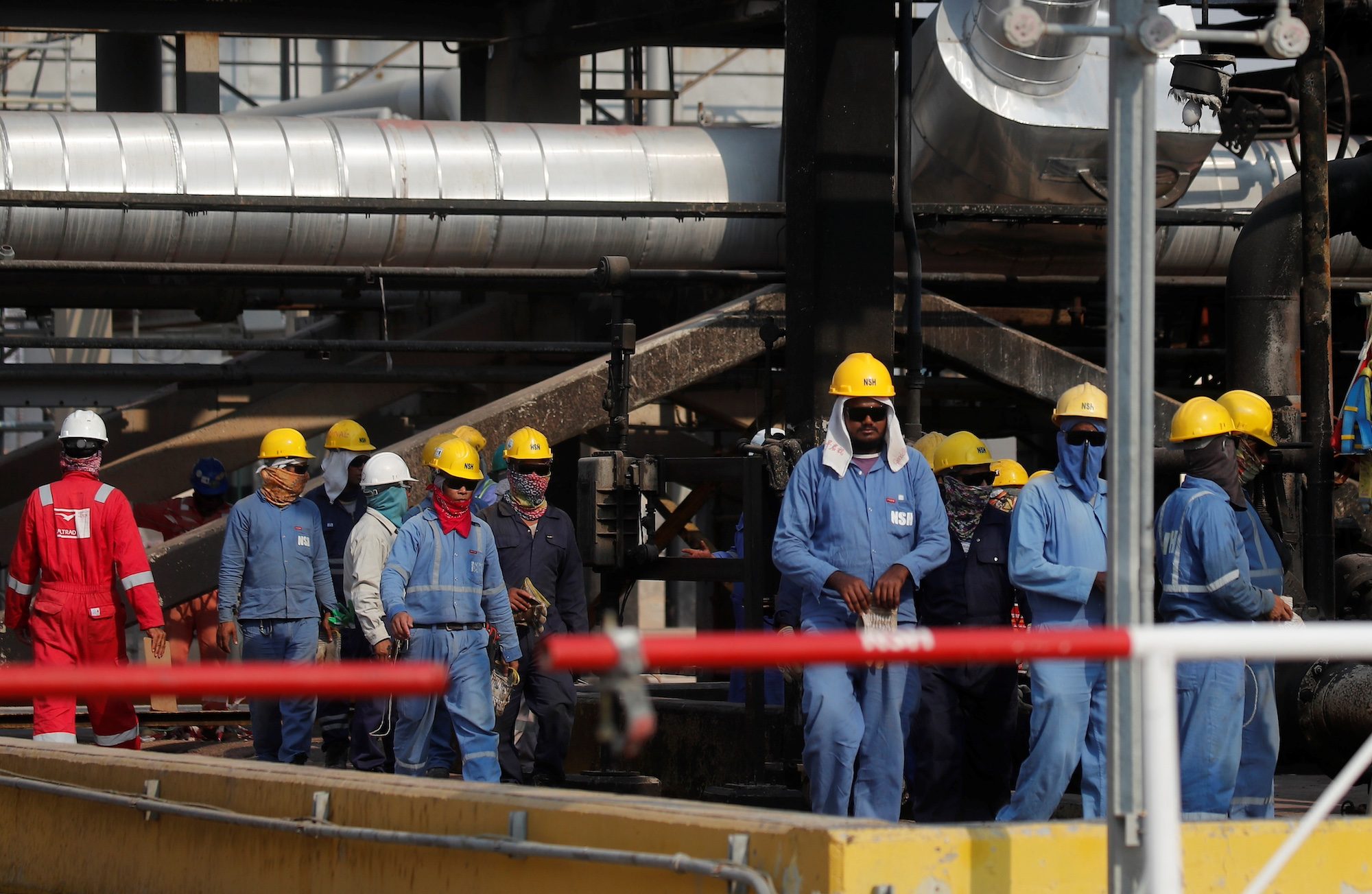Clothing, Hardhat, Helmet Workers walk at Saudi Aramco oil facility in Abqaiq, Saudi Arabia October 12, 2019. REUTERS/Maxim Shemetov