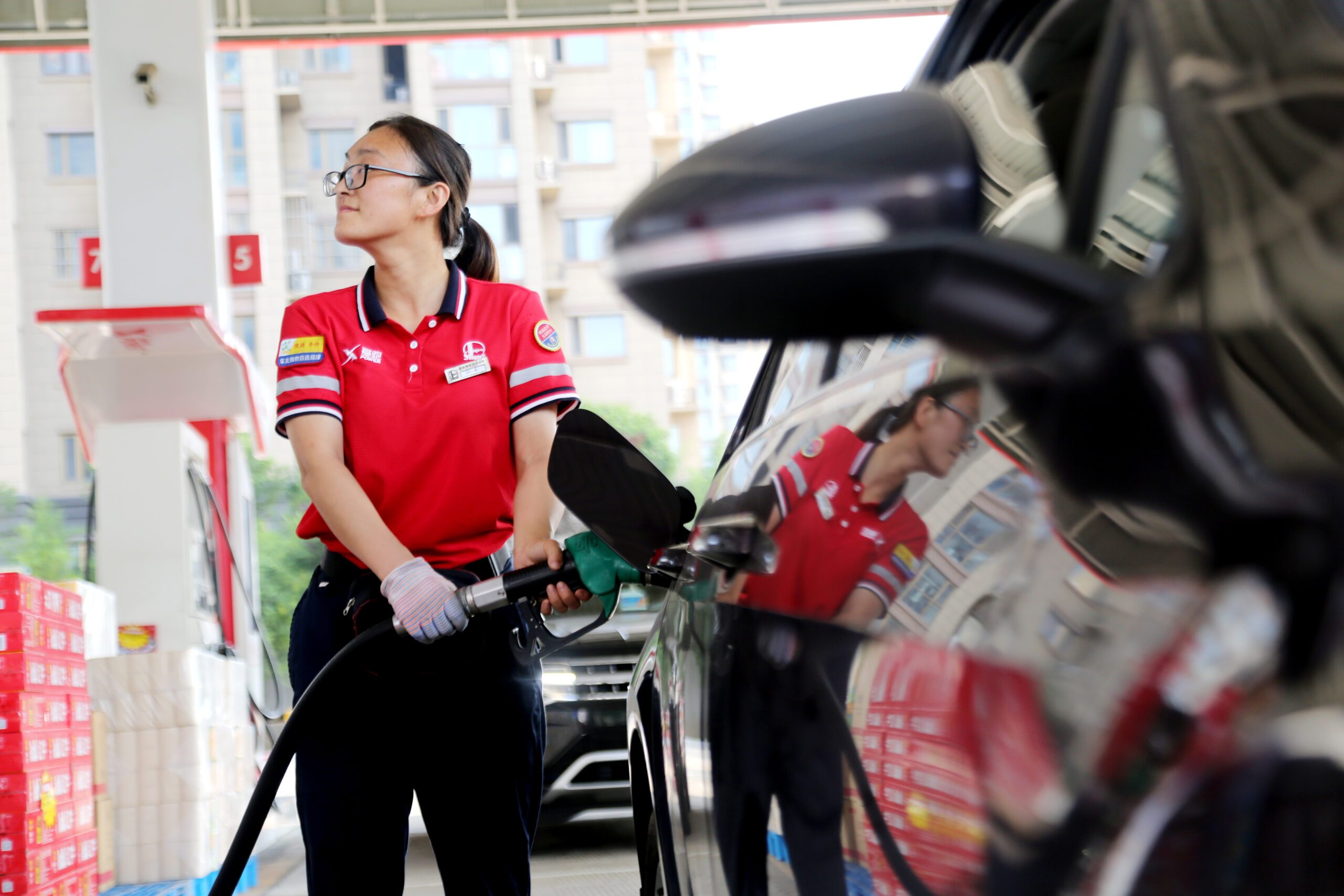 An attendant fills up a car at a petrol station in Jiangsu province, east China. The country has just cut benchmark lending rates to revive the economy