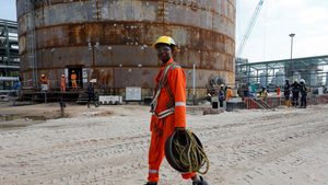 A construction worker walks through the Dangote Oil Refinery, southeast of Nigeria's capital. The refinery began processing in January 2024