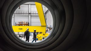 Workers outside a Hyperloop Transportation Technologies tunnel segment. The company is now working on projects in Italy, France, the US and Germany